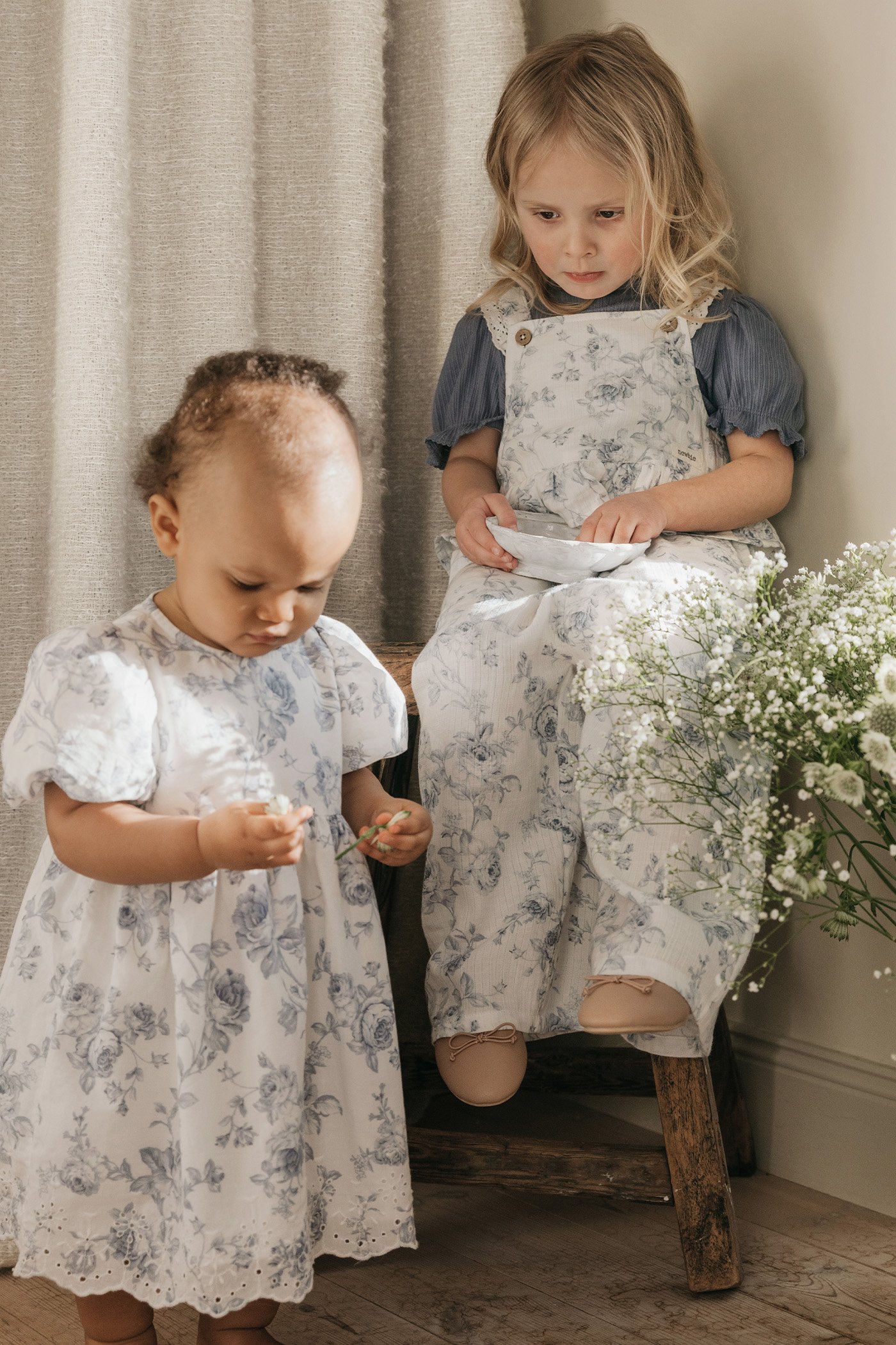 Girls in marine‑inspired, floral garments