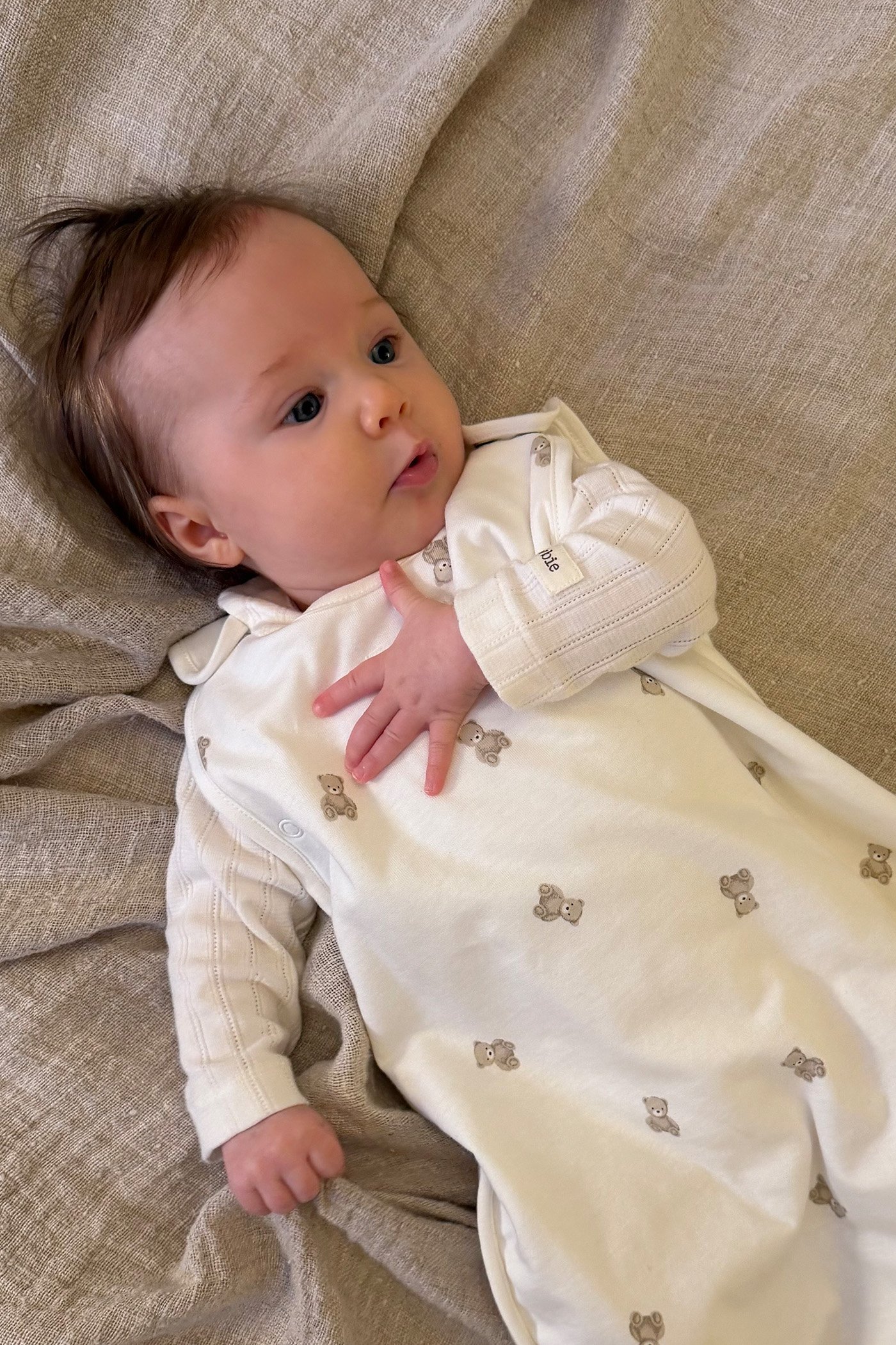 Babyjunge im Schlafsack mit Teddybärmuster