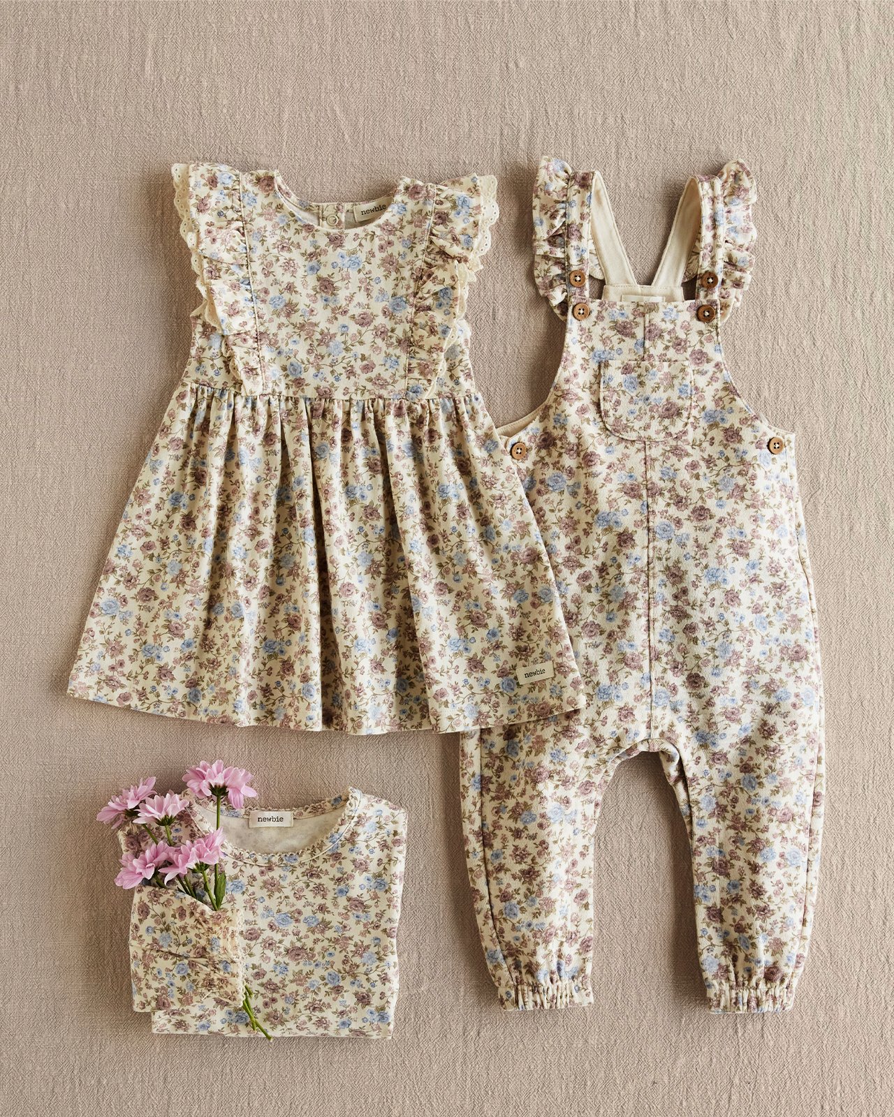 A flat lay of floral clothing, dress and jumpsuit