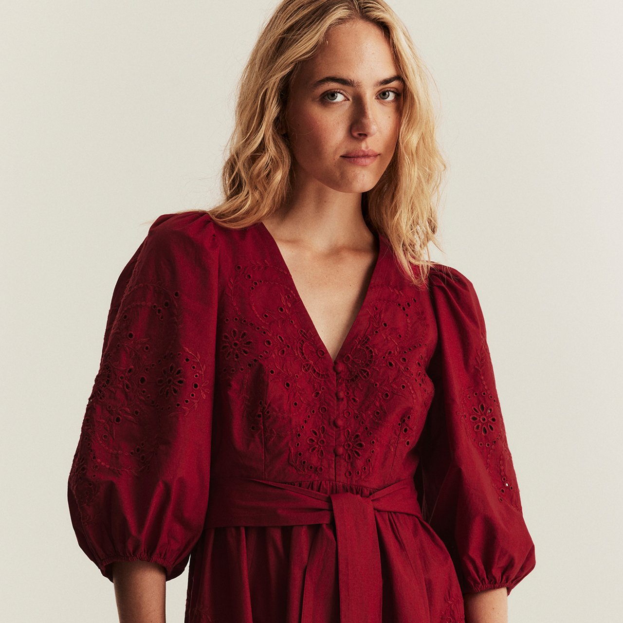 Woman wearing a plaid blouse with ruffled sleeves.