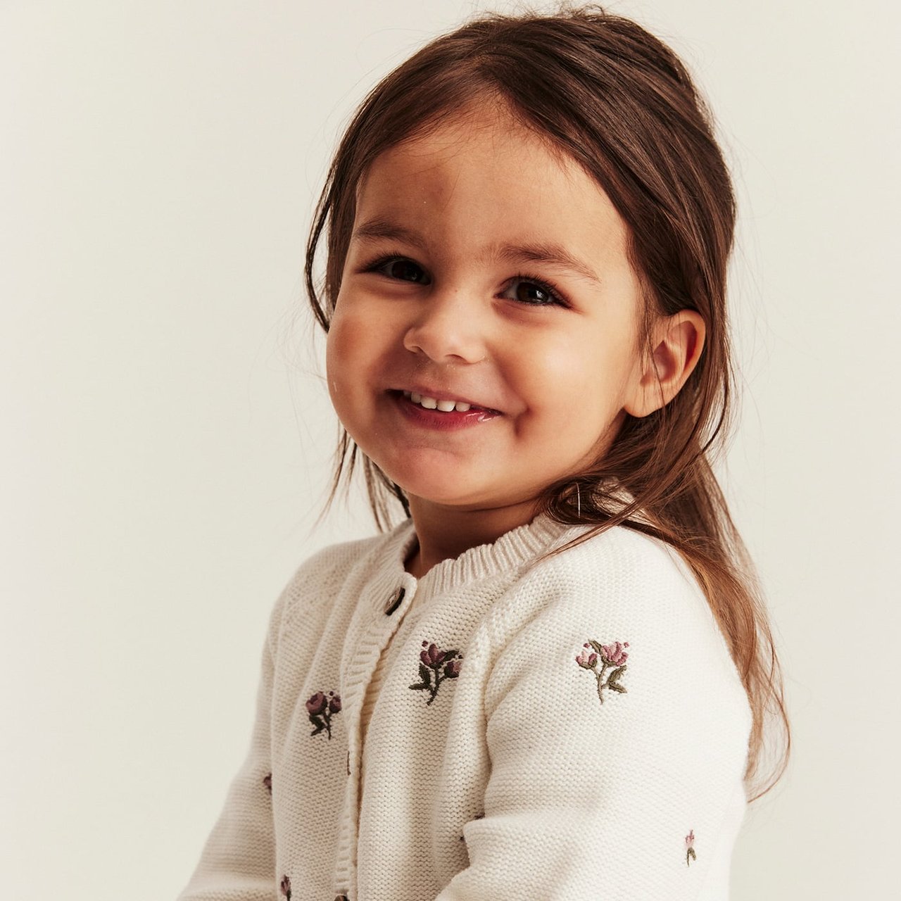 Light yellow short-sleeved jumpsuit with delicate embroidery and ruffle sleeves, worn by child.