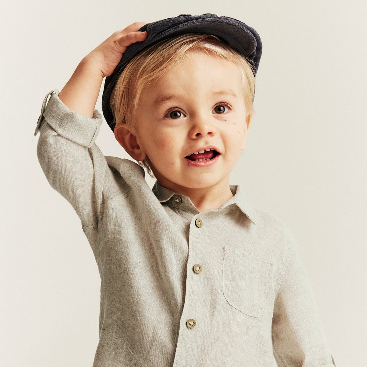 Baby boy in beige shirt and a hat