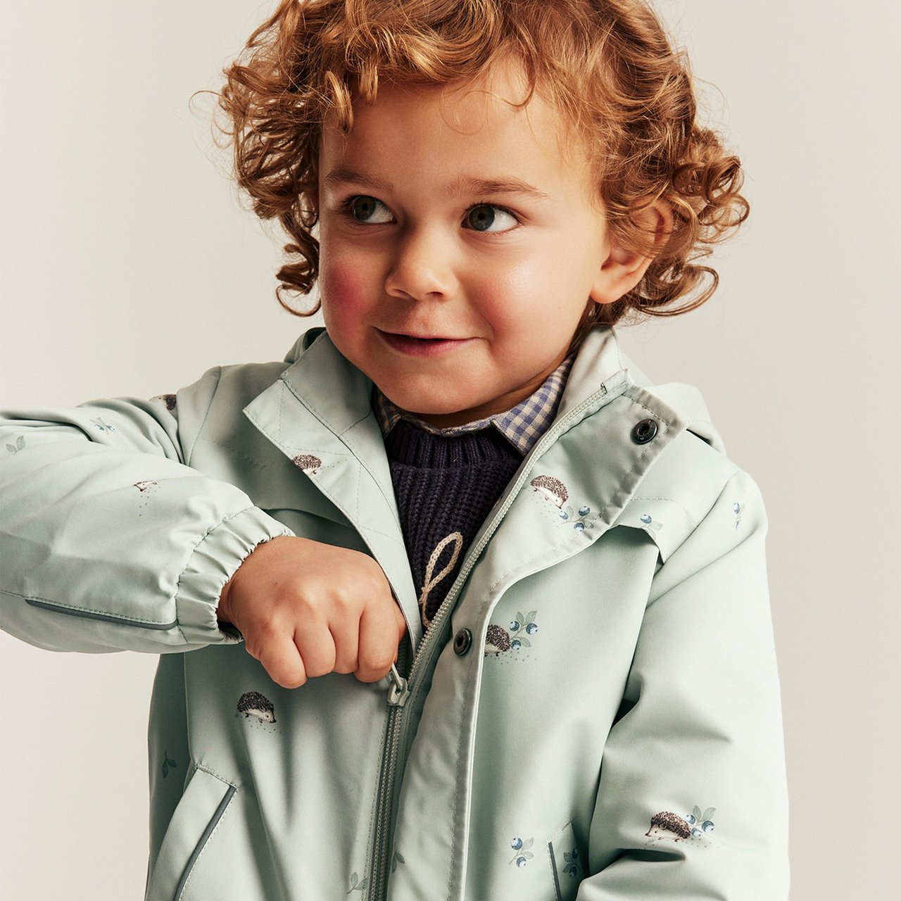 Boy wearing jacket with a hedgehog print on it