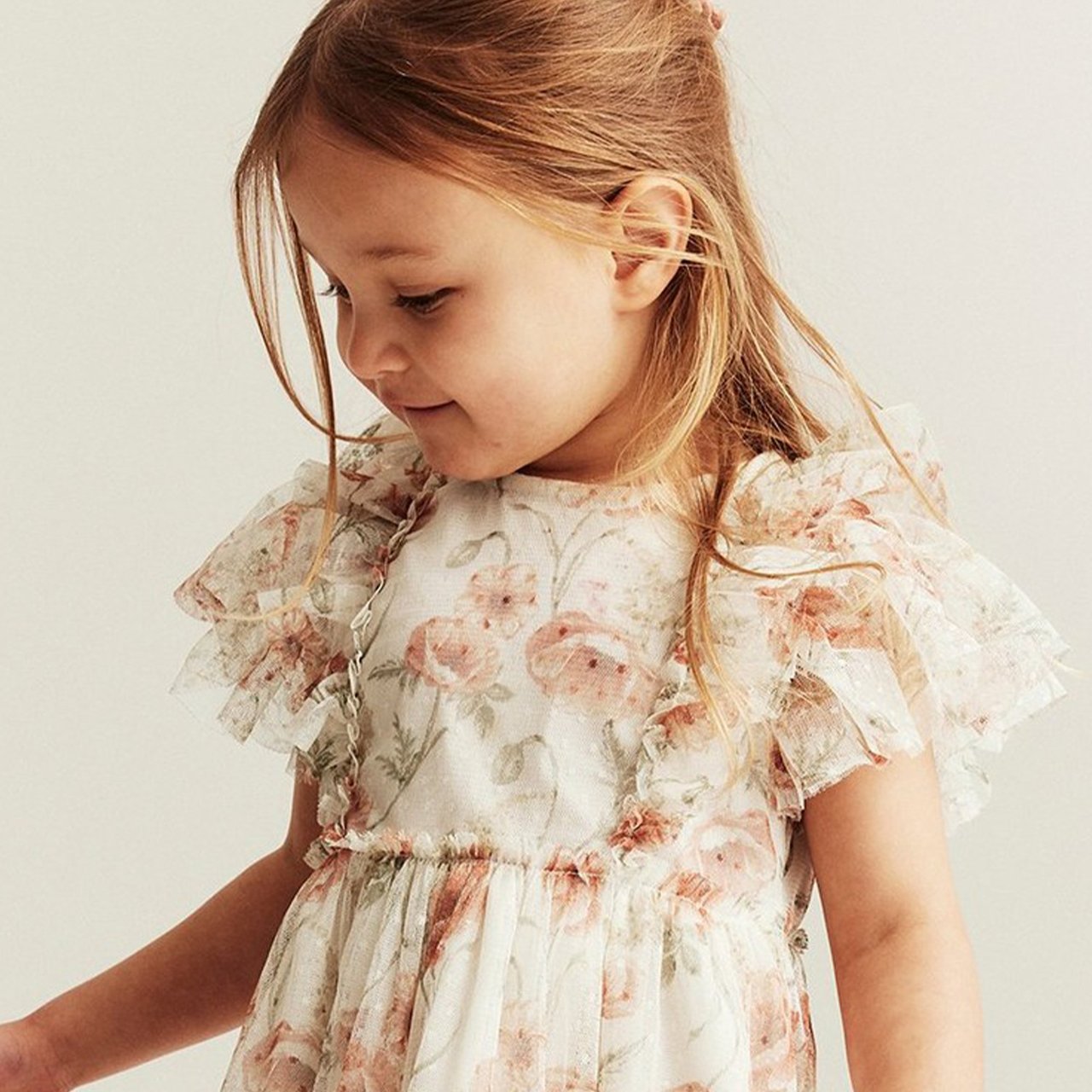 Girl wearing a floral mesh dress with frills