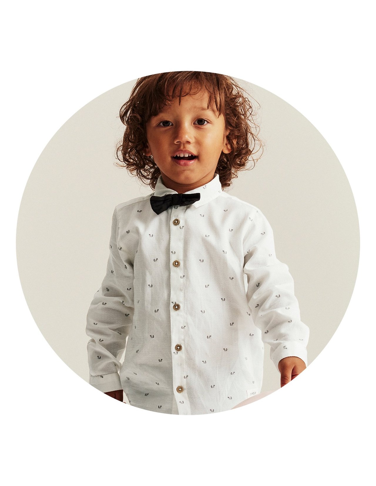 Boy in white shirt with small racoon print and bow tie