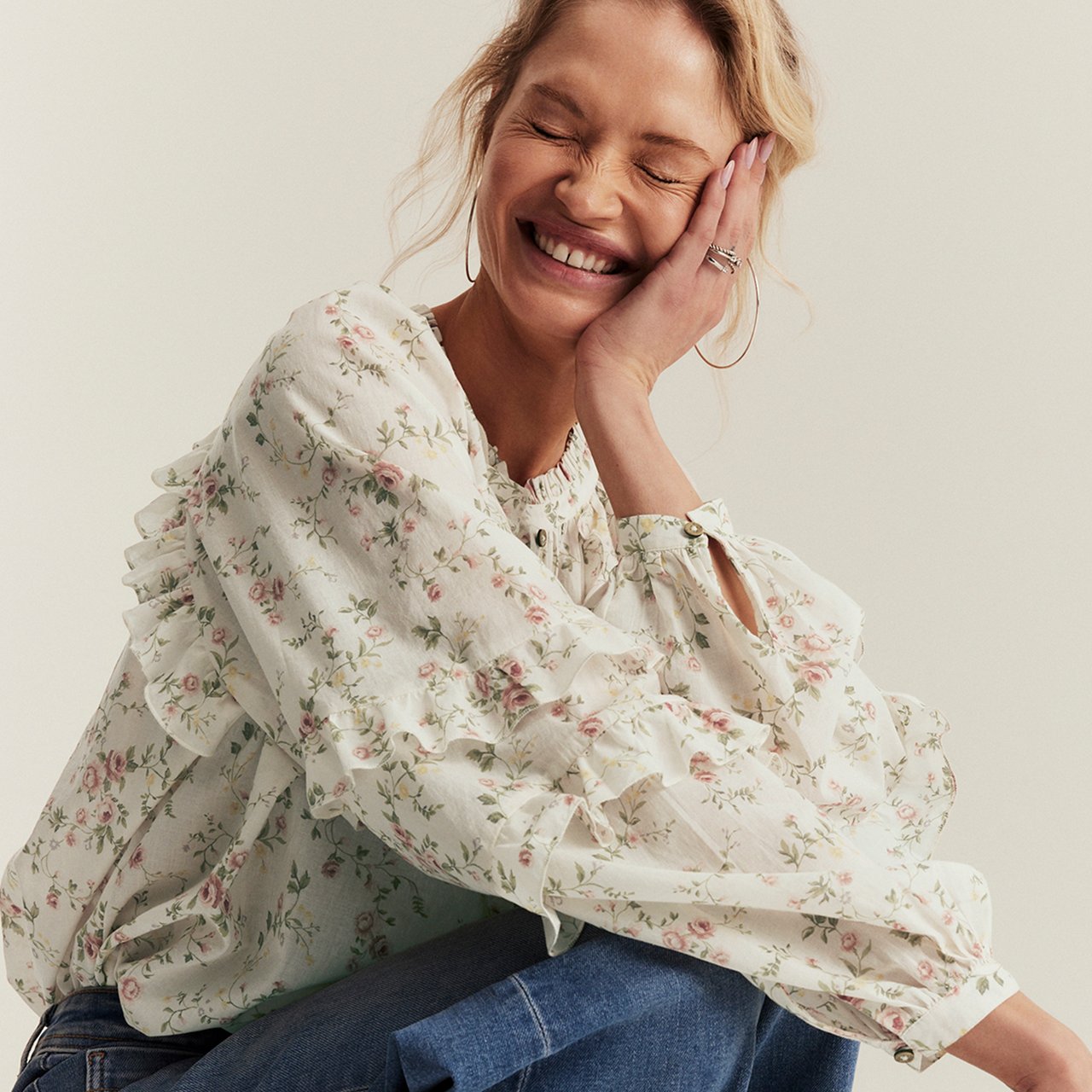 Woman wearing a frilled blouse with a small flower pattern on it