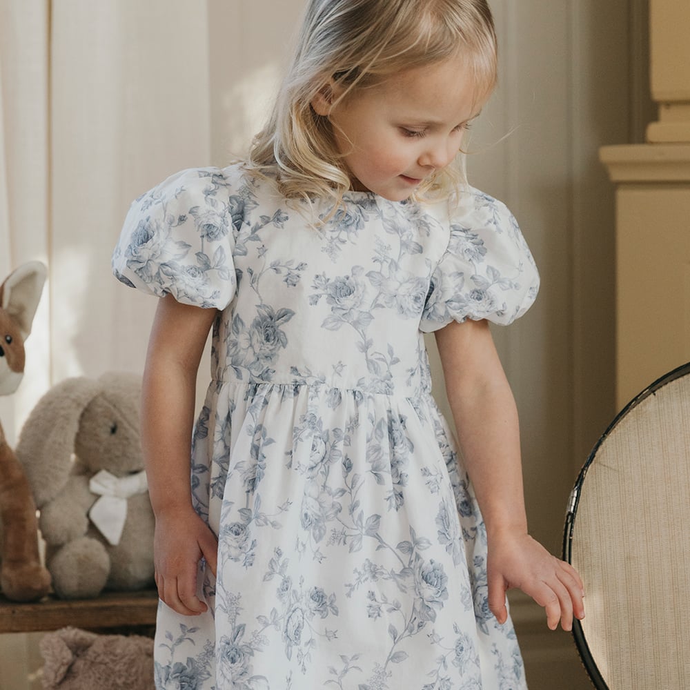 Girl wearing a white dress with a blue flower pattern