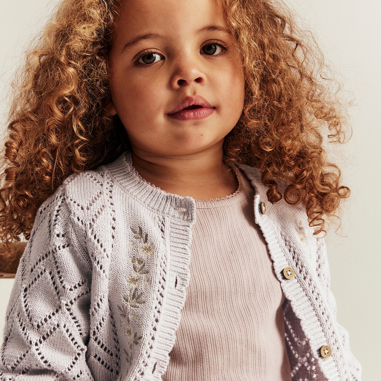 Little girl wearing a lilac cardigan