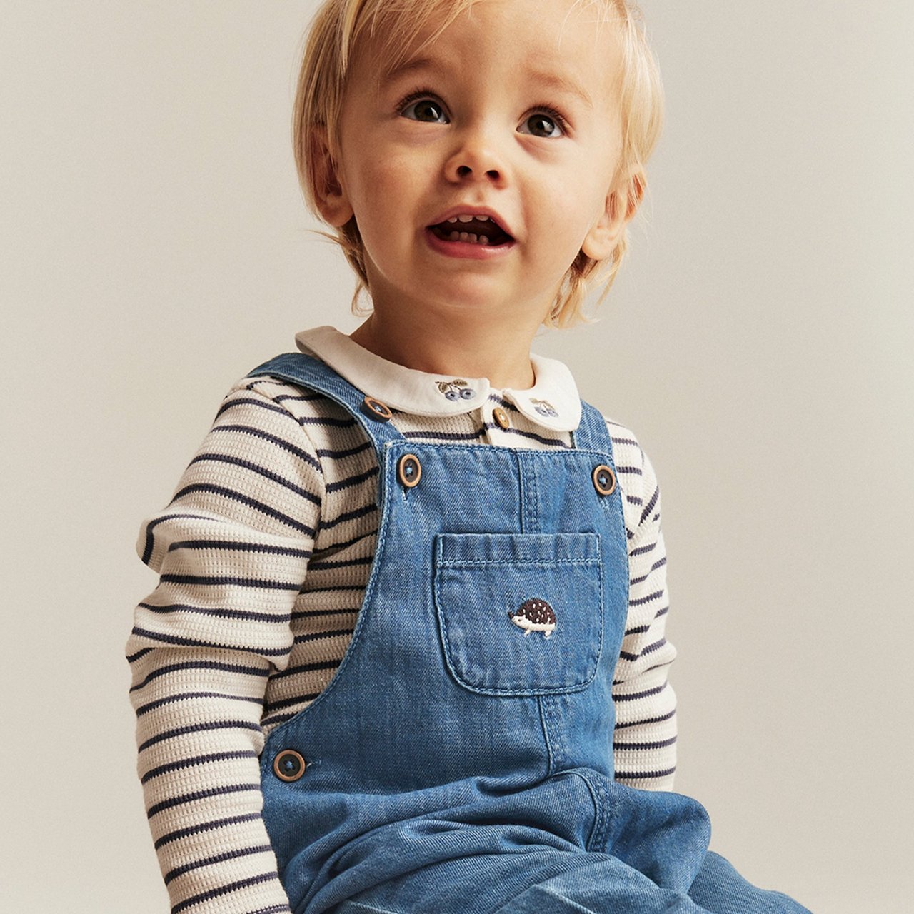 Little boy wearing a blue denim dungaree