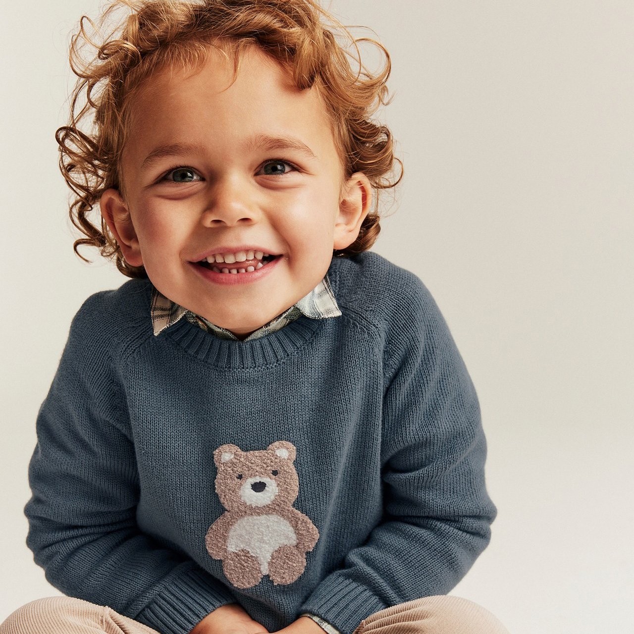 Boy in blue jumper with bear print