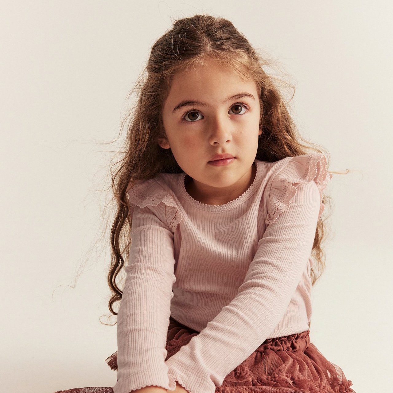 Girl with pink top with frills on shoulders