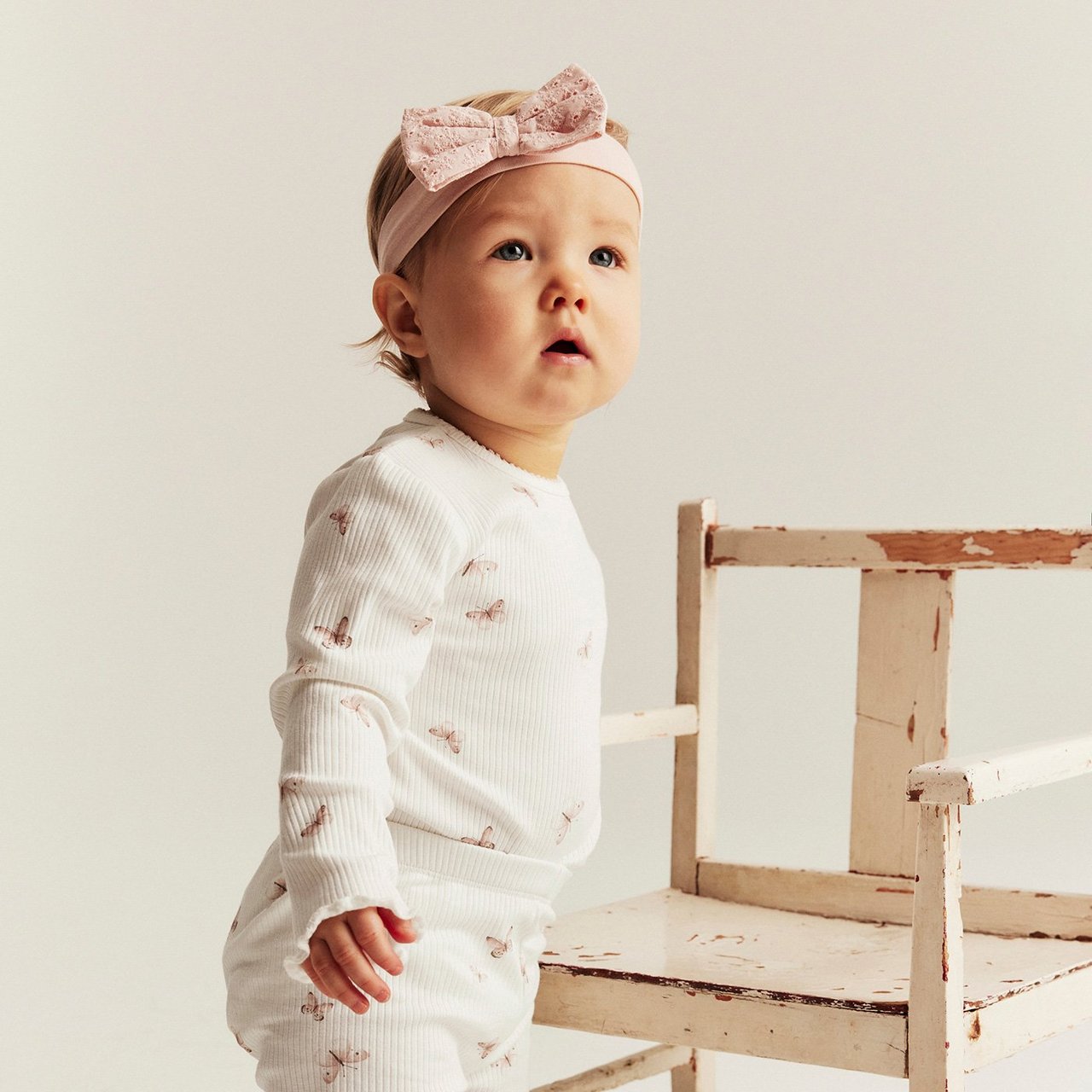 Baby girl with white bodysuit and headband