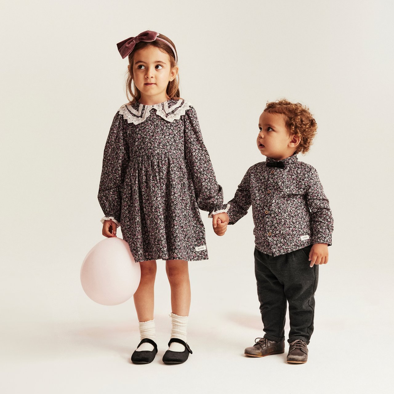 Siblings holding hand in matching outfits