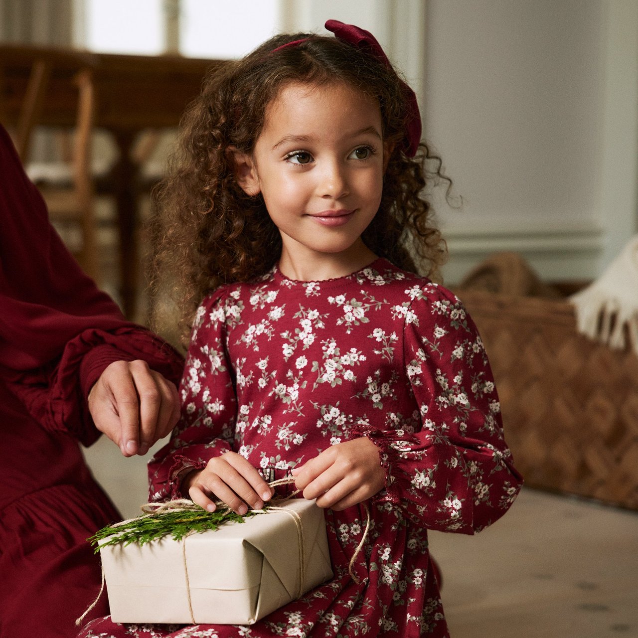 Girl wearing a red christmas sweater with white flowers on
