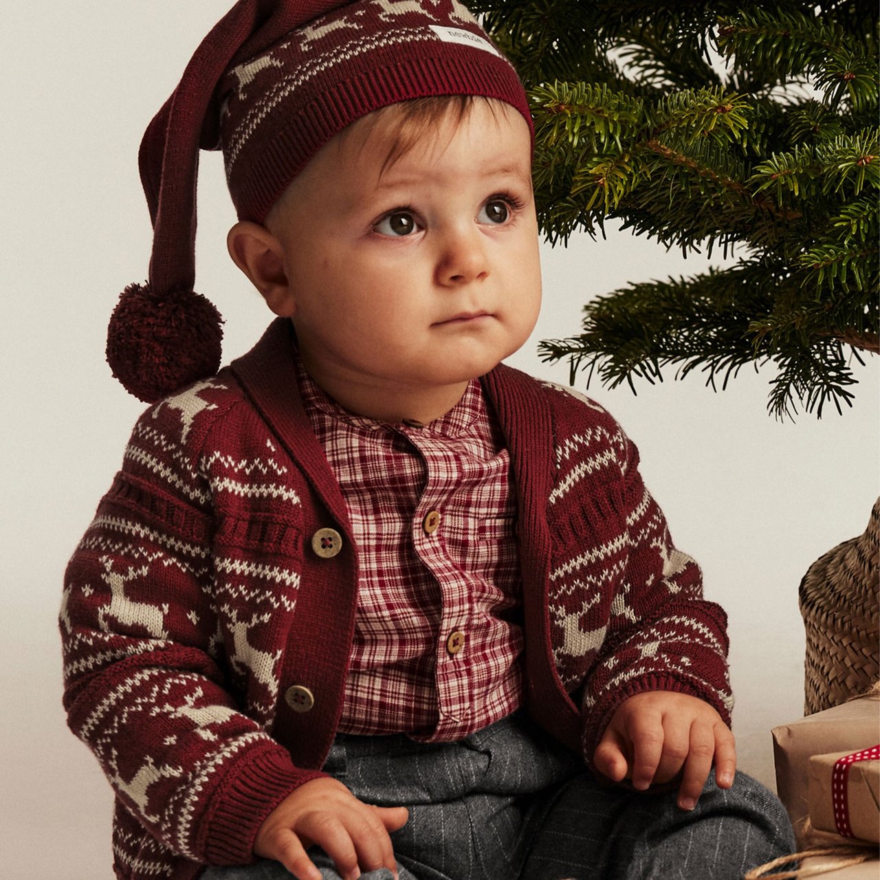 boy wearing a christmas hat and cardigan