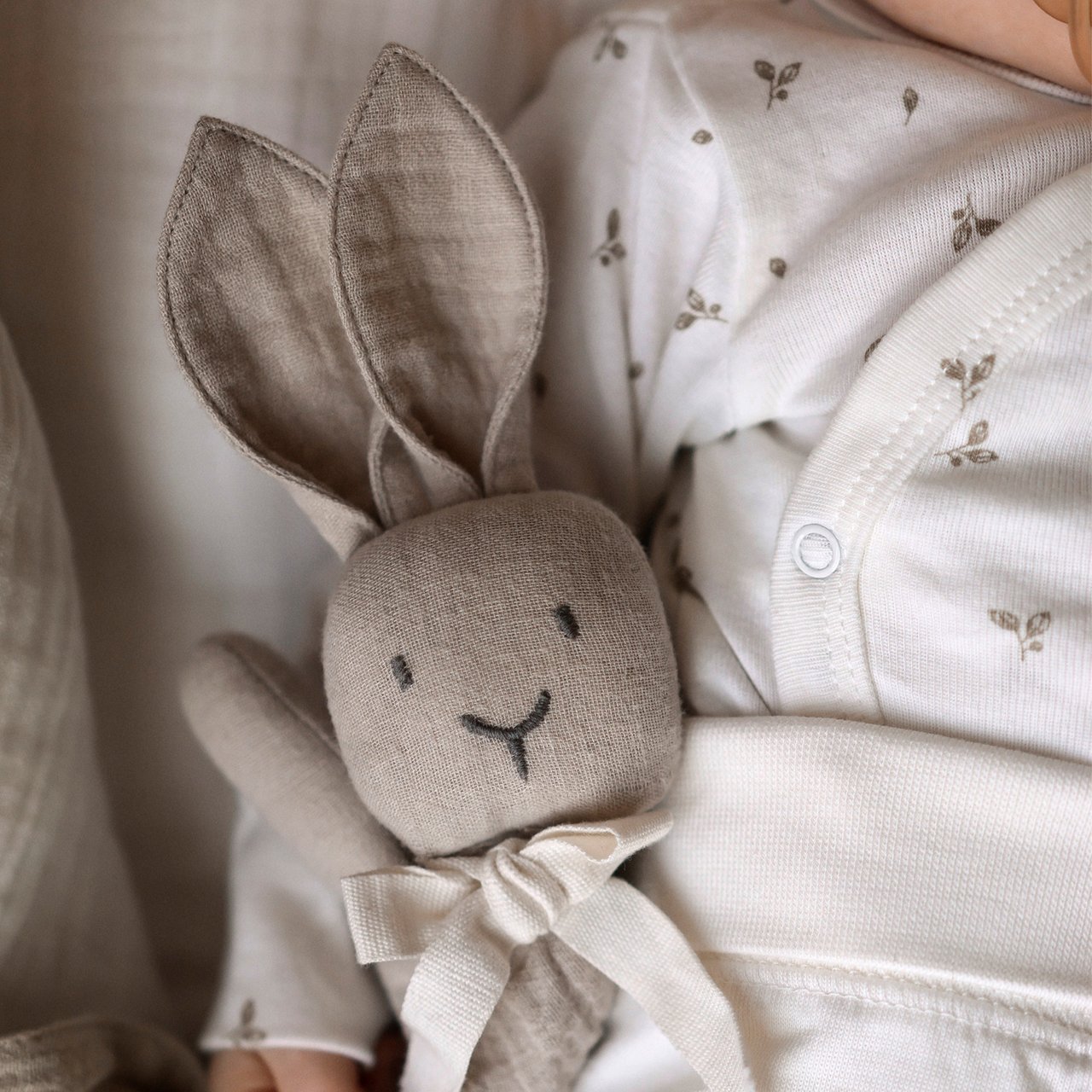 Newborn baby holding a toy rabbit