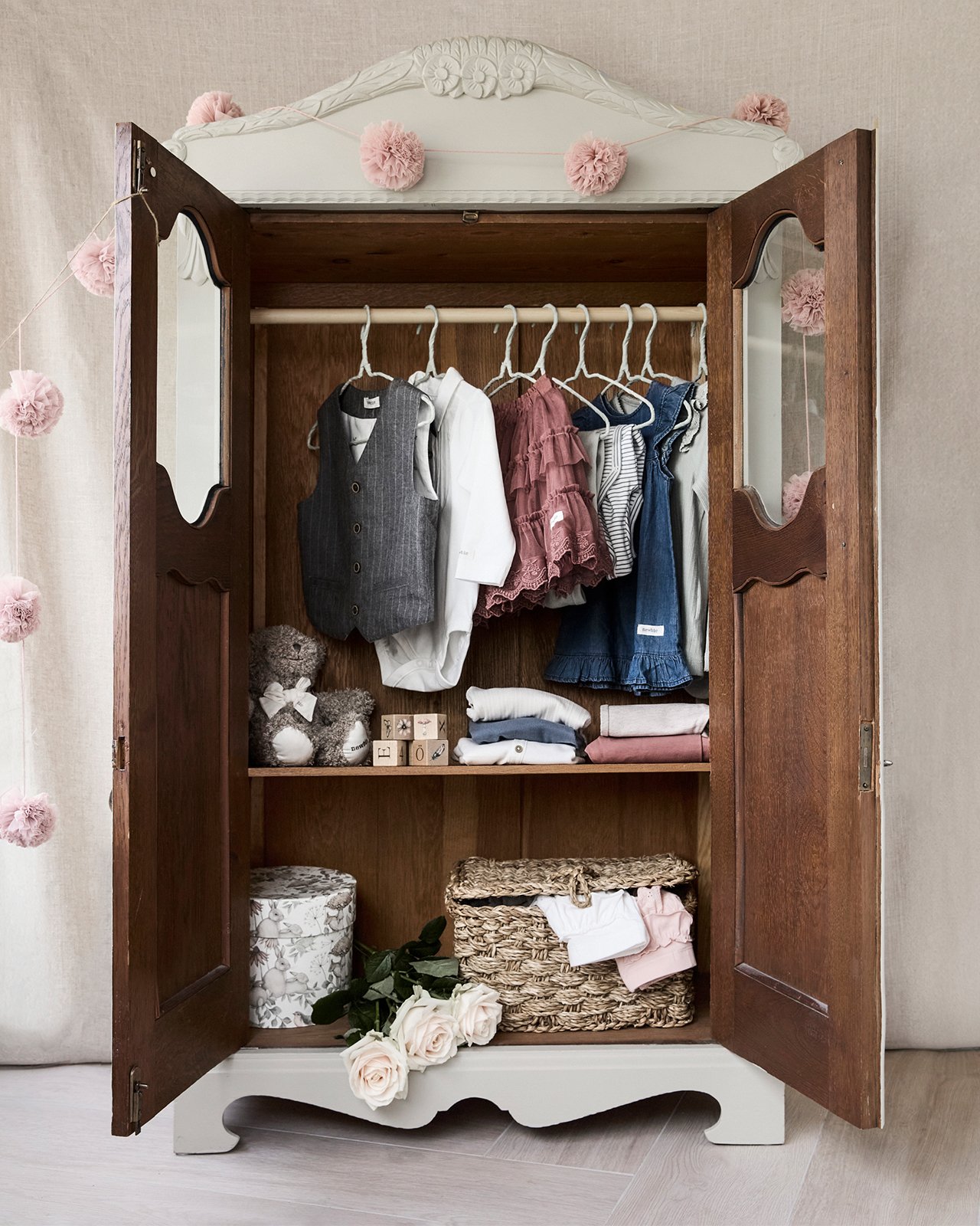 Children's clothing set with tops, skirt, and vest arranged with roses.
