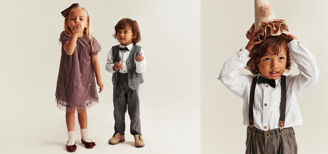 A boy and girl wearing festive clothing, and a boy wearing a party hat.