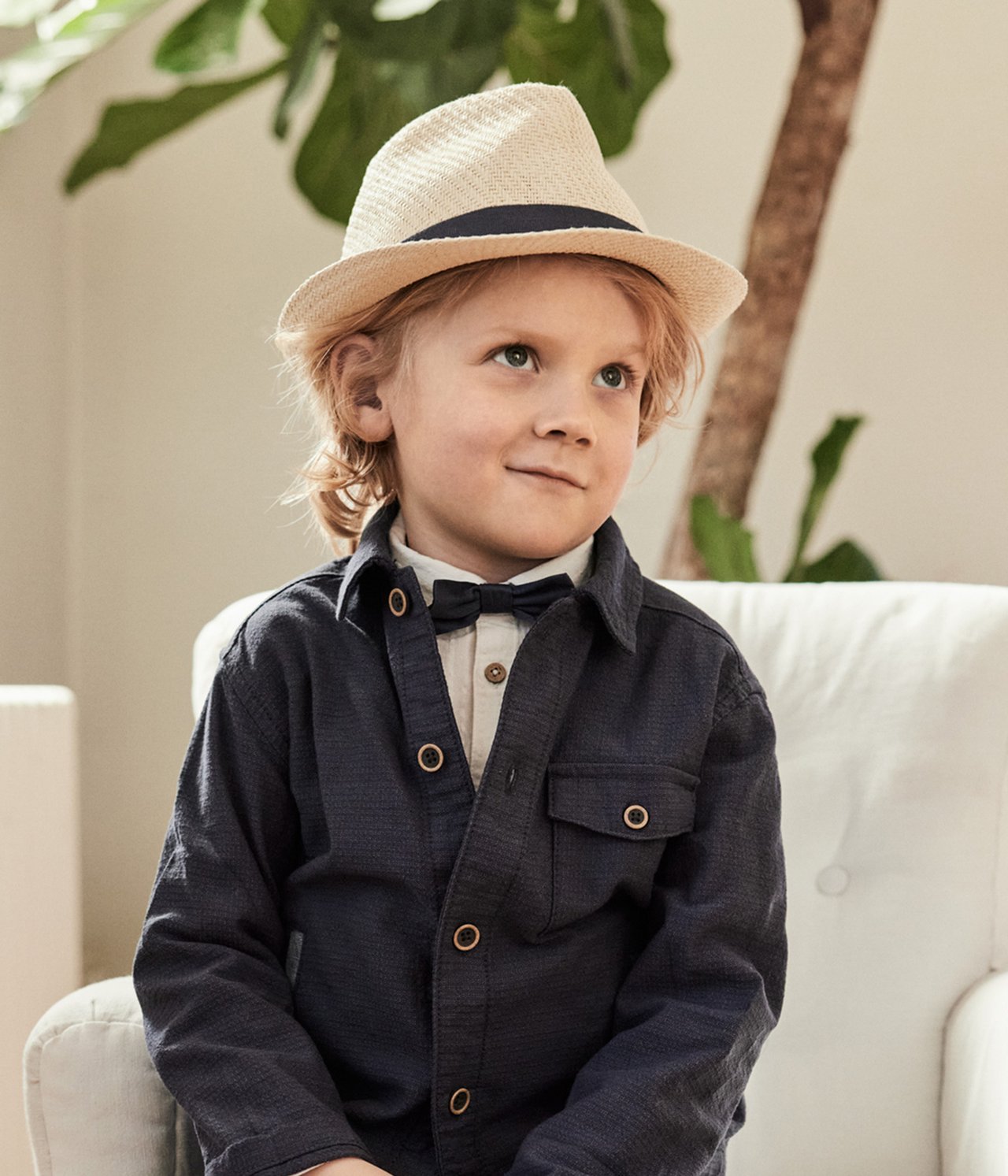 Boy in blue overshirt and bow