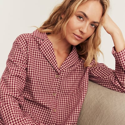Woman wearing a red-and-white gingham pajama shirt.