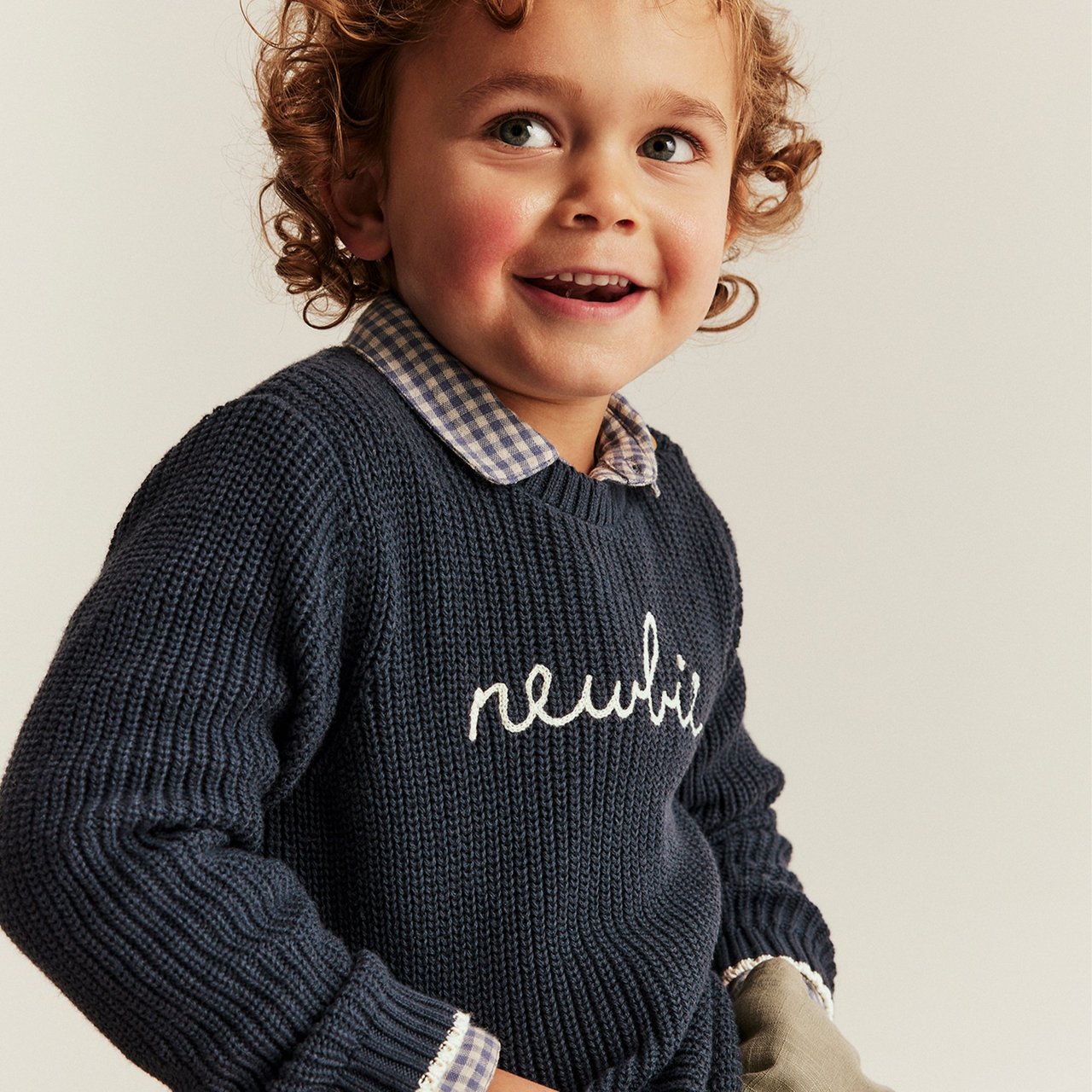 Boy wearing a blue shirt with newbie logo on it