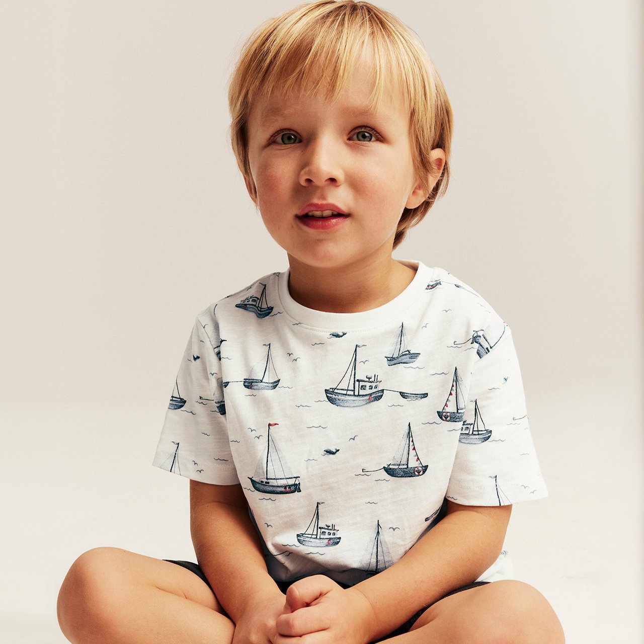 Boy in white t-shirt with sail-boat pattern