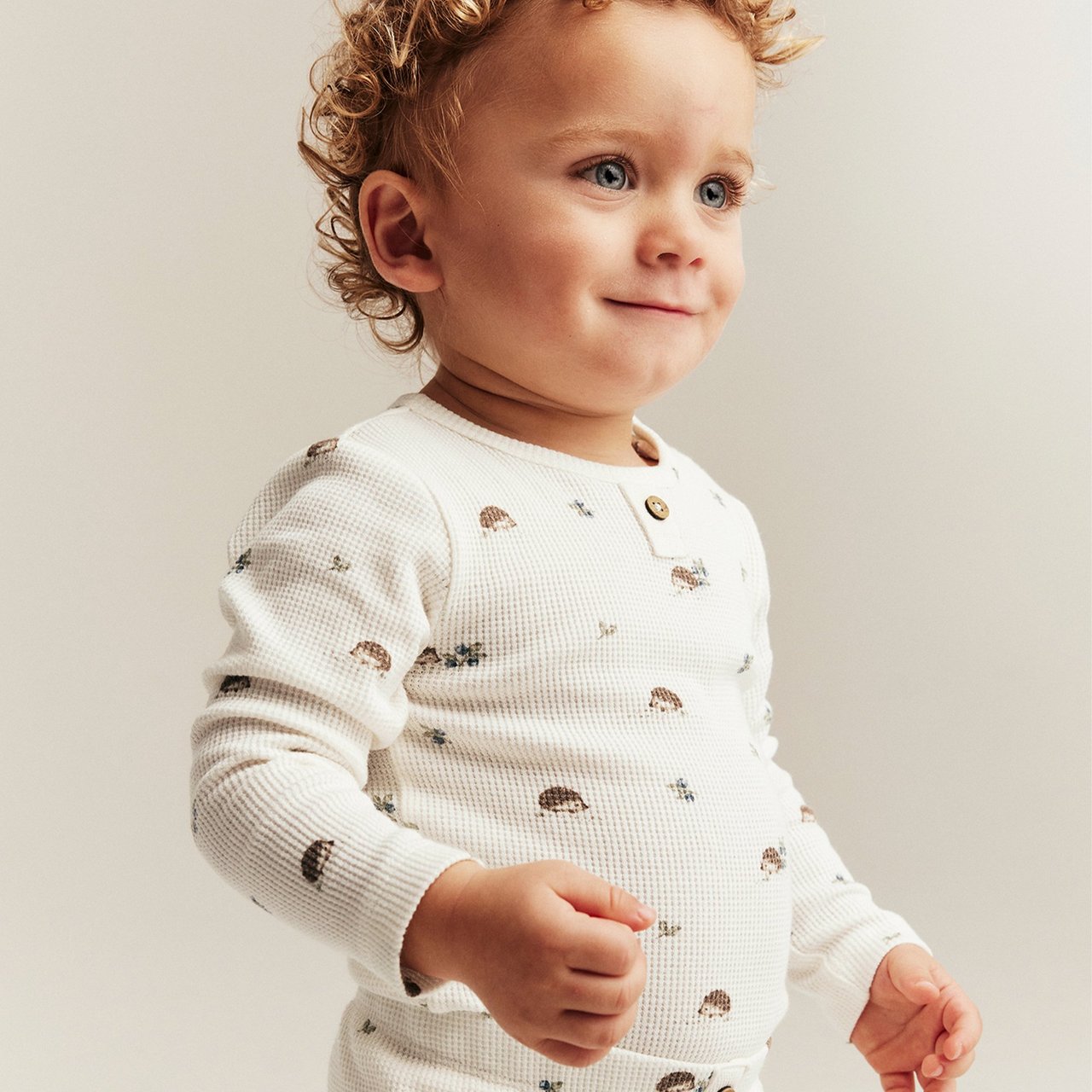Baby boy in white set with hedgehog print