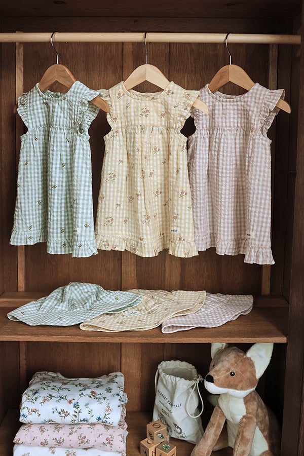 Dresses made from rescued cotton fabrics hanging in a wardrobe