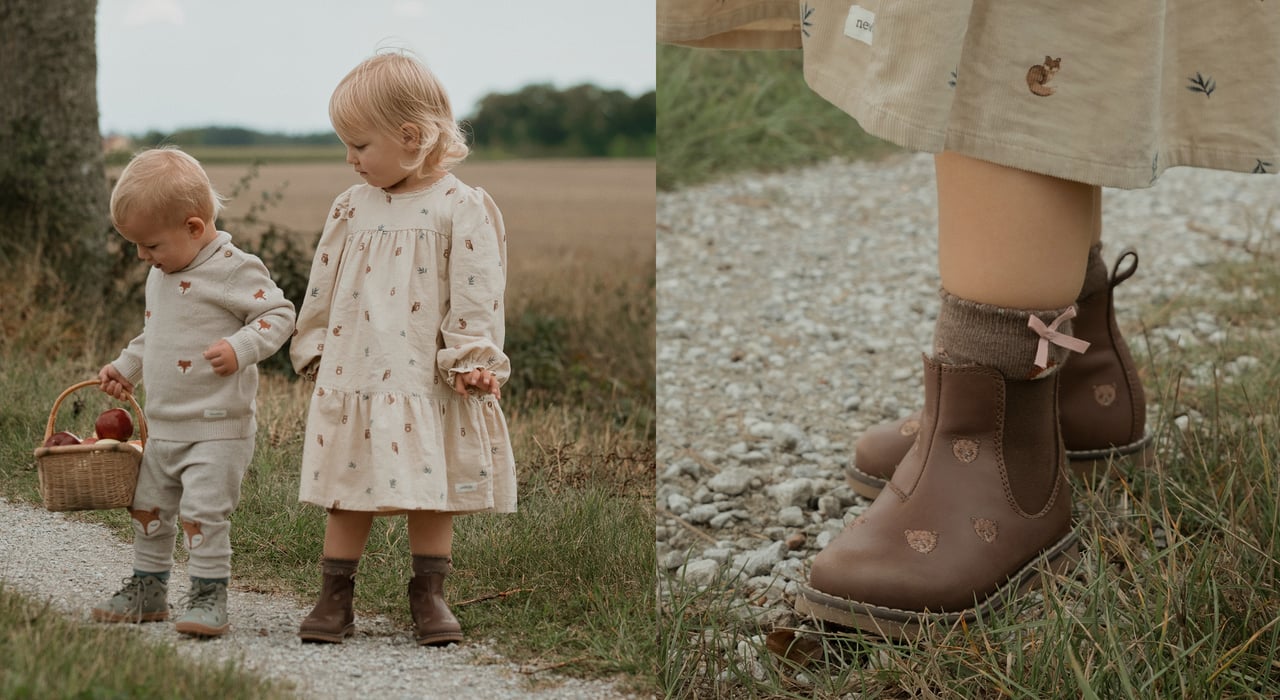 Dusty pink leather Chelsea boots with embroidered floral details, displayed in a wicker basket with dried flowers.