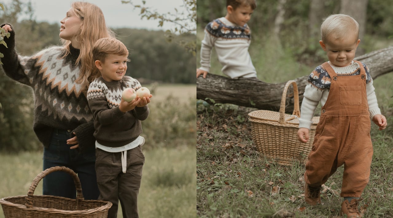 Zwei Kinder in gemusterten Strickpullovern und braunen Overalls auf einem Baumstamm im Wald