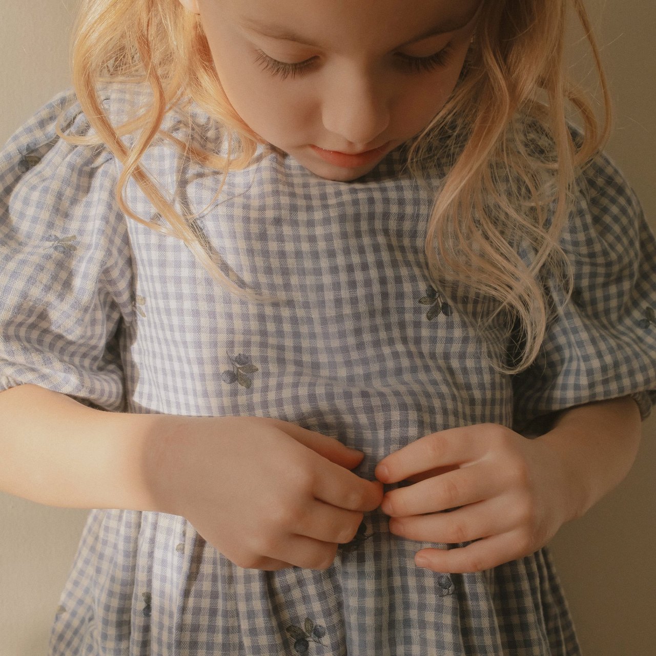 Girl wearing a checked dress with blueberry print