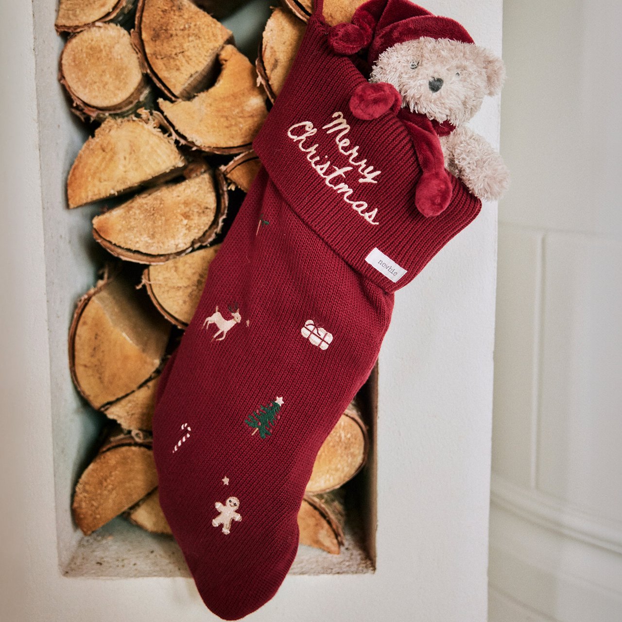 Roter Weihnachtsstrumpf mit festlicher Stickerei, Teddybär und Mütze mit „Merry Christmas“