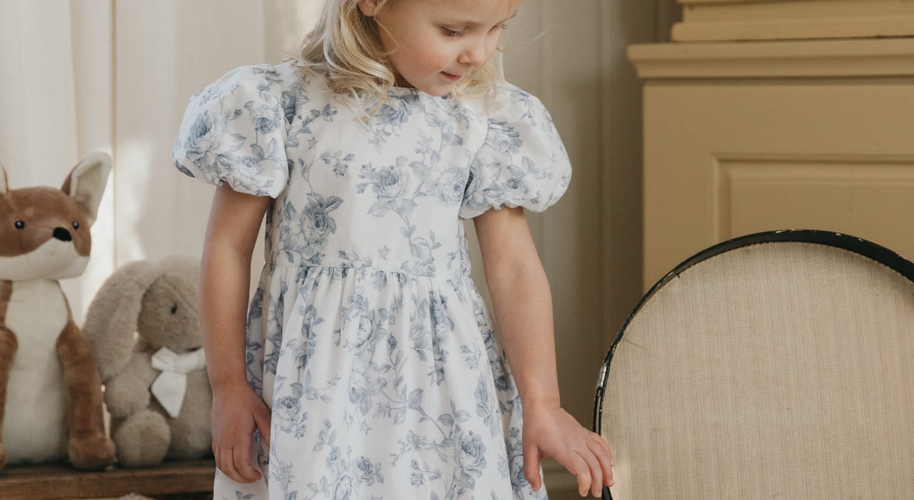 Blondes Mädchen in einem geblümten Kleid