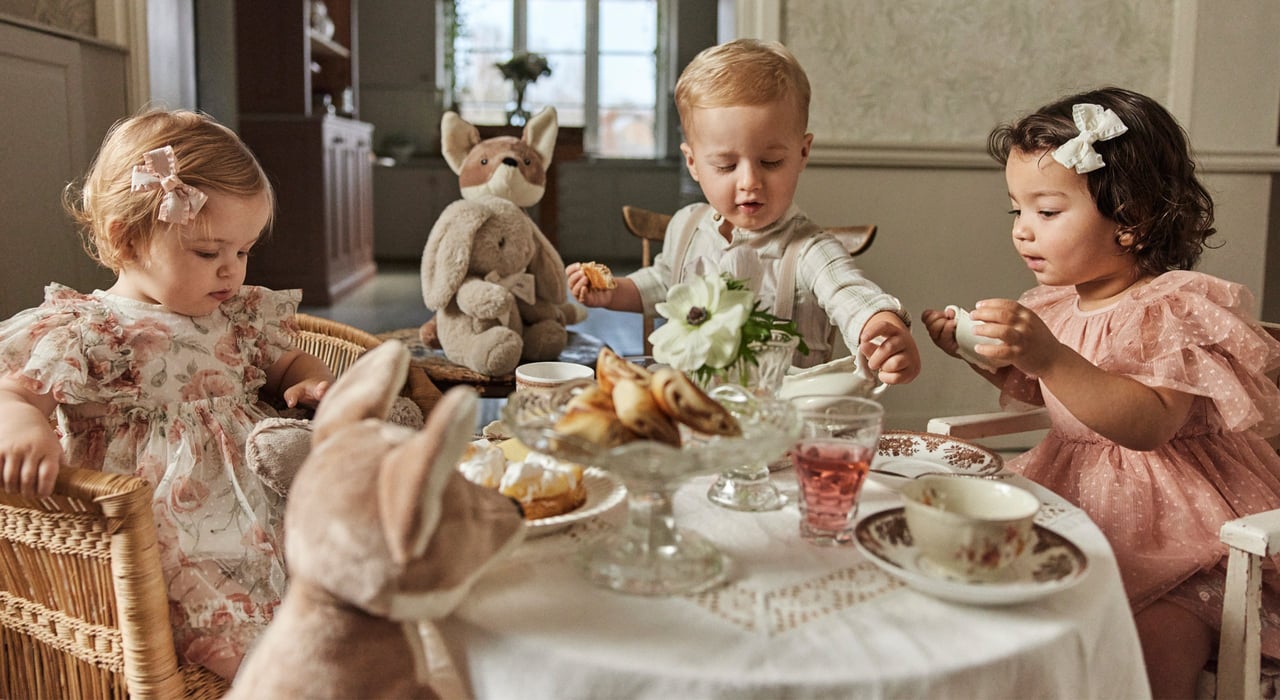 Kids having a tea party wearing cute occasionwear