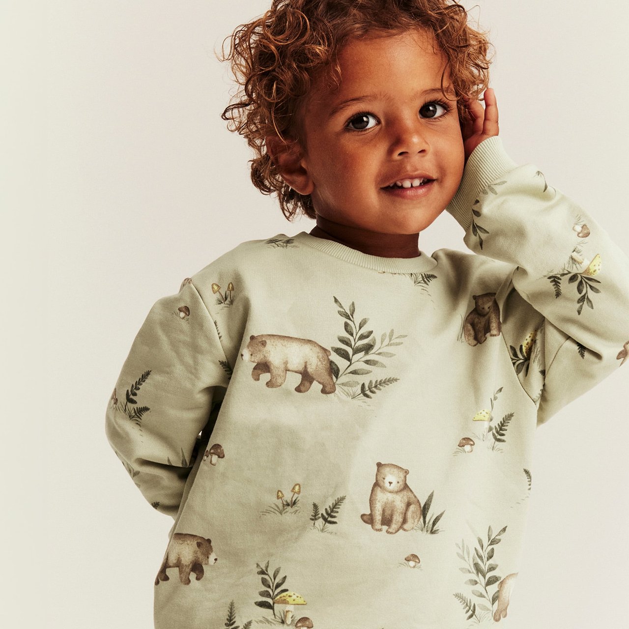 Light green sweatshirt with bear print, woodland motifs and long sleeves for toddlers.