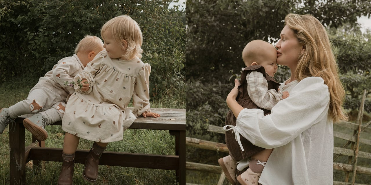 Two young children in nature-inspired outfits playing outdoors and sitting on a wooden bench