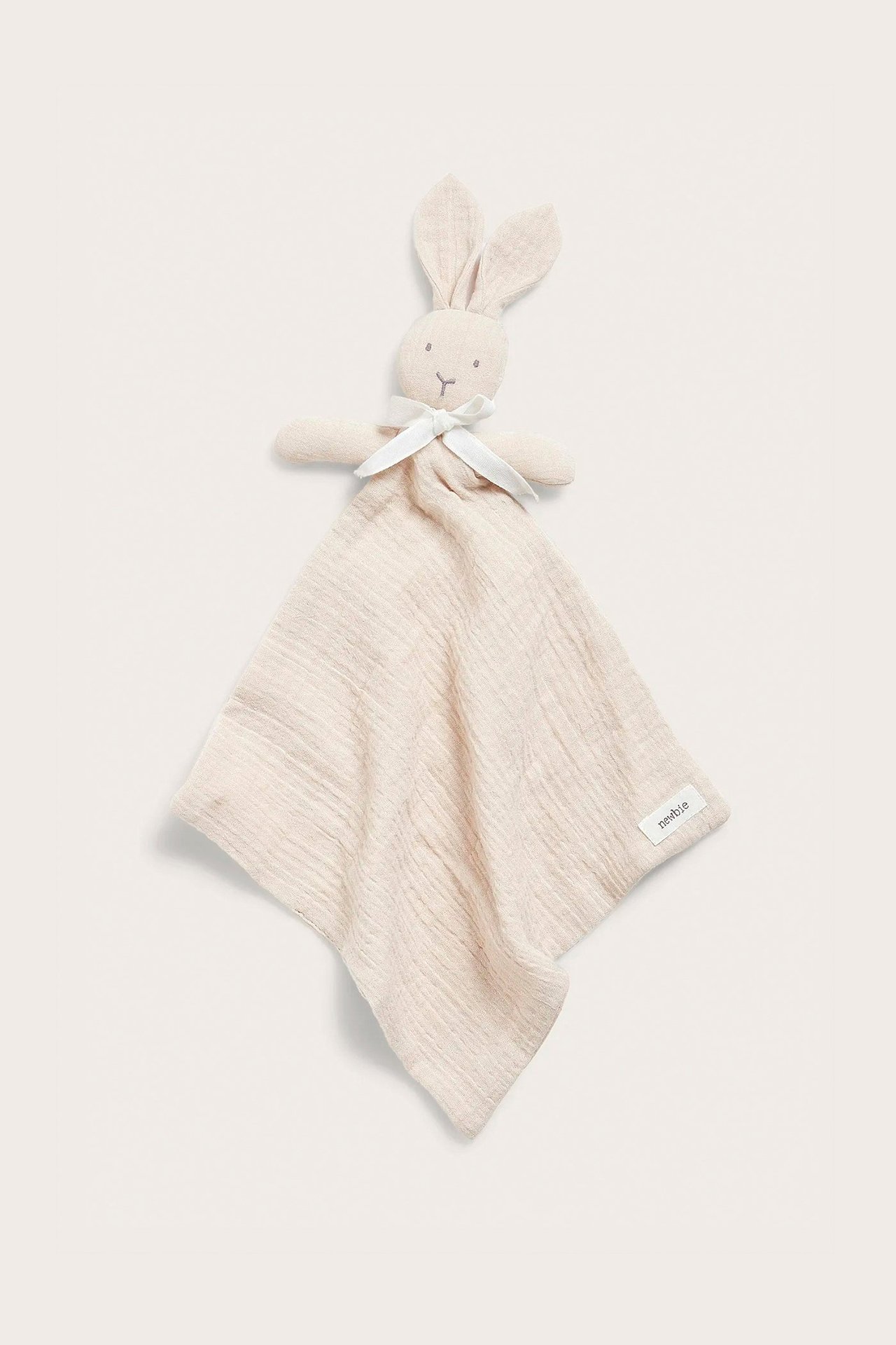Vorderansicht eines hellbeigen, weichen Baumwoll-Schmusetuchs mit Hasenkopf und weißem Band.