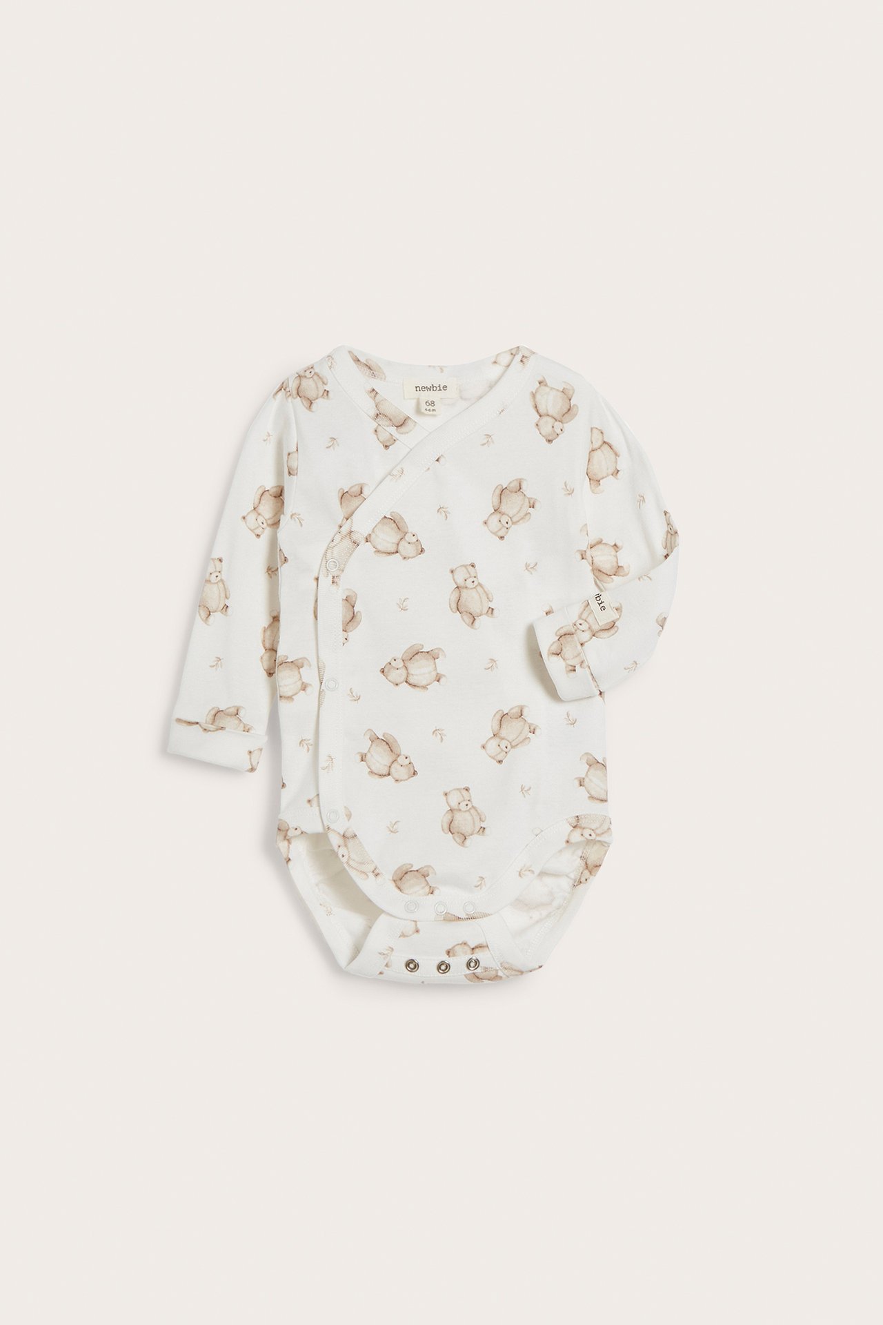 Front view: Offwhite baby wrap bodysuit with long sleeves, brown teddy bear pattern, and popper buttons.