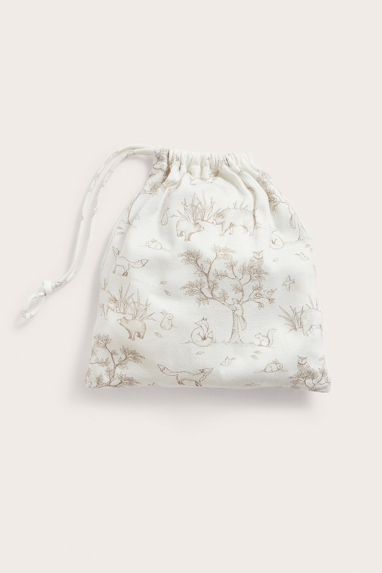 Front view of an off-white cotton patterned drawstring gift bag with nature and animal illustrations.