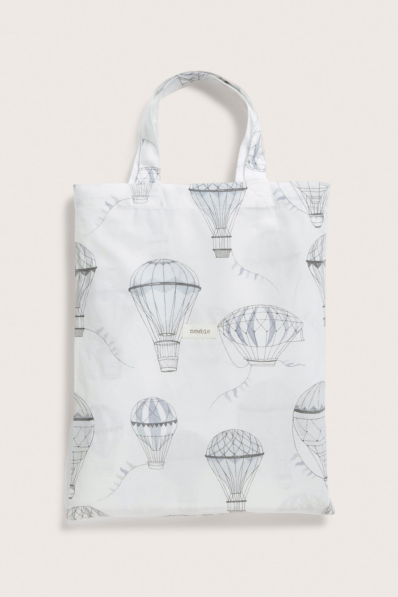 Vorderansicht einer cremefarbenen Baumwolltasche mit grauem Heißluftballonmuster und zwei Henkeln.