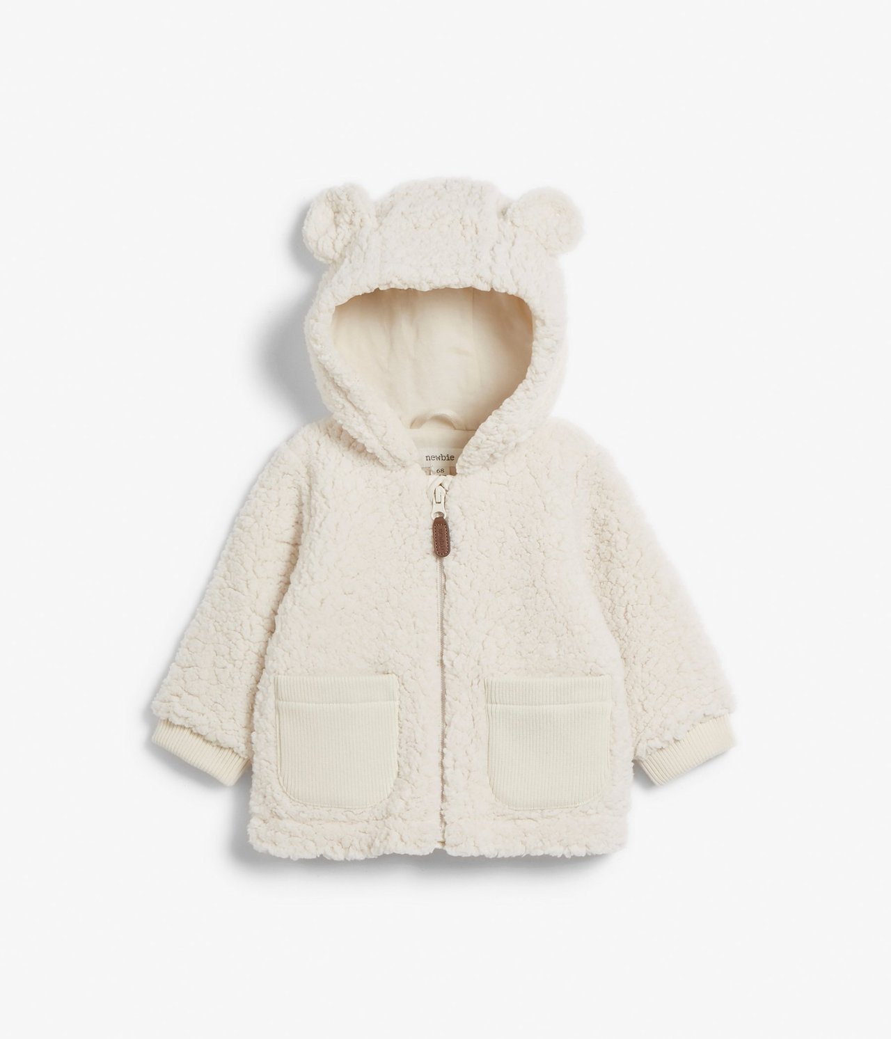 Front view of a white baby teddy fur jacket with bear ears, zip, and ribbed pockets.