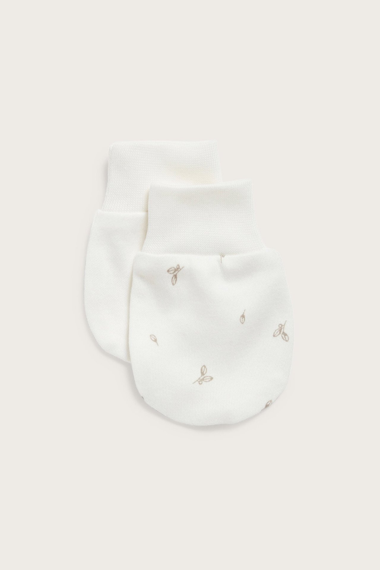 Front view of two off-white baby mittens with a subtle leaf pattern and ribbed cuffs.