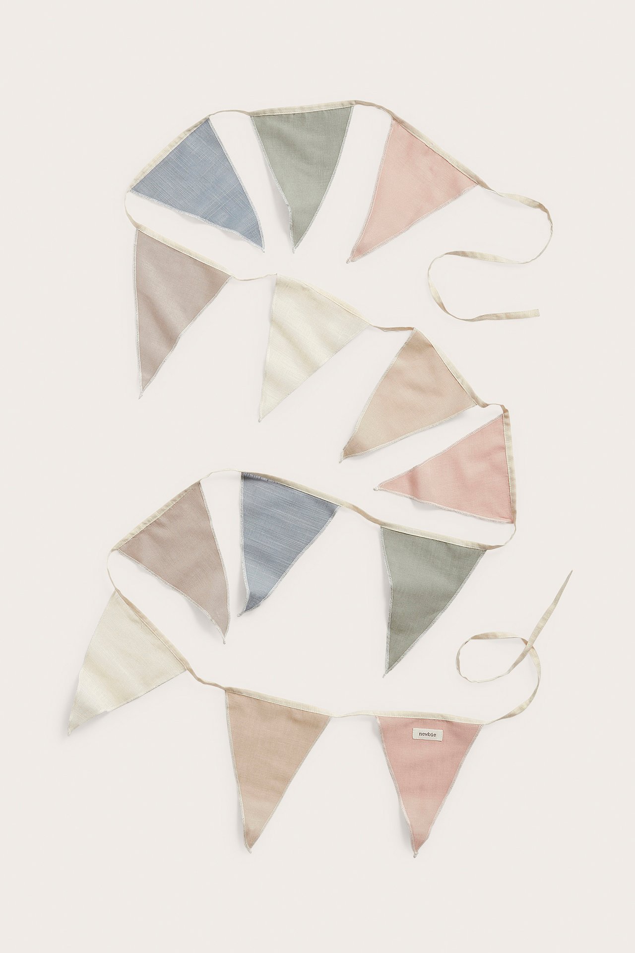 Top-down view: two cotton pennant strands with multicolored triangular flags in beige, blue, green, pink.