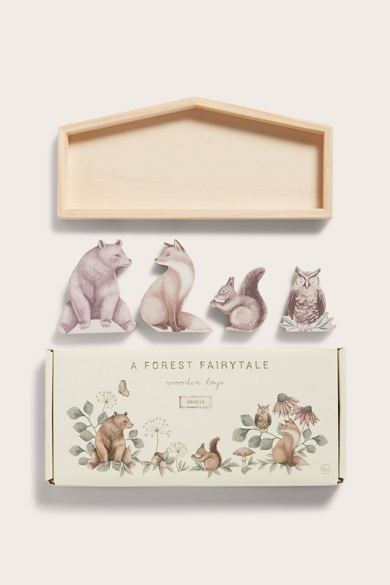 Draufsicht: Vier beige Holztiere, eine hausförmige Ablage und eine gemusterte Schachtel.