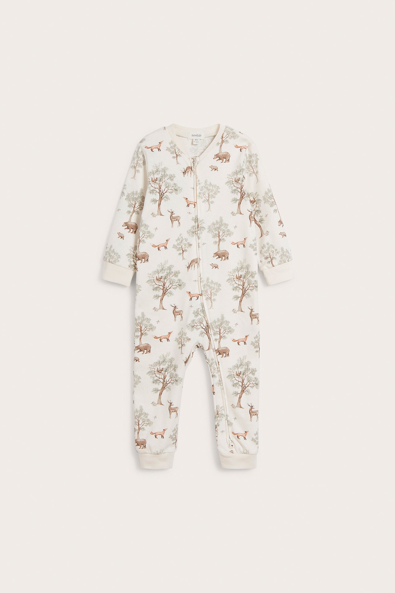 Front view of an off-white baby pyjamas with a forest print and a two-way zipper down the front.