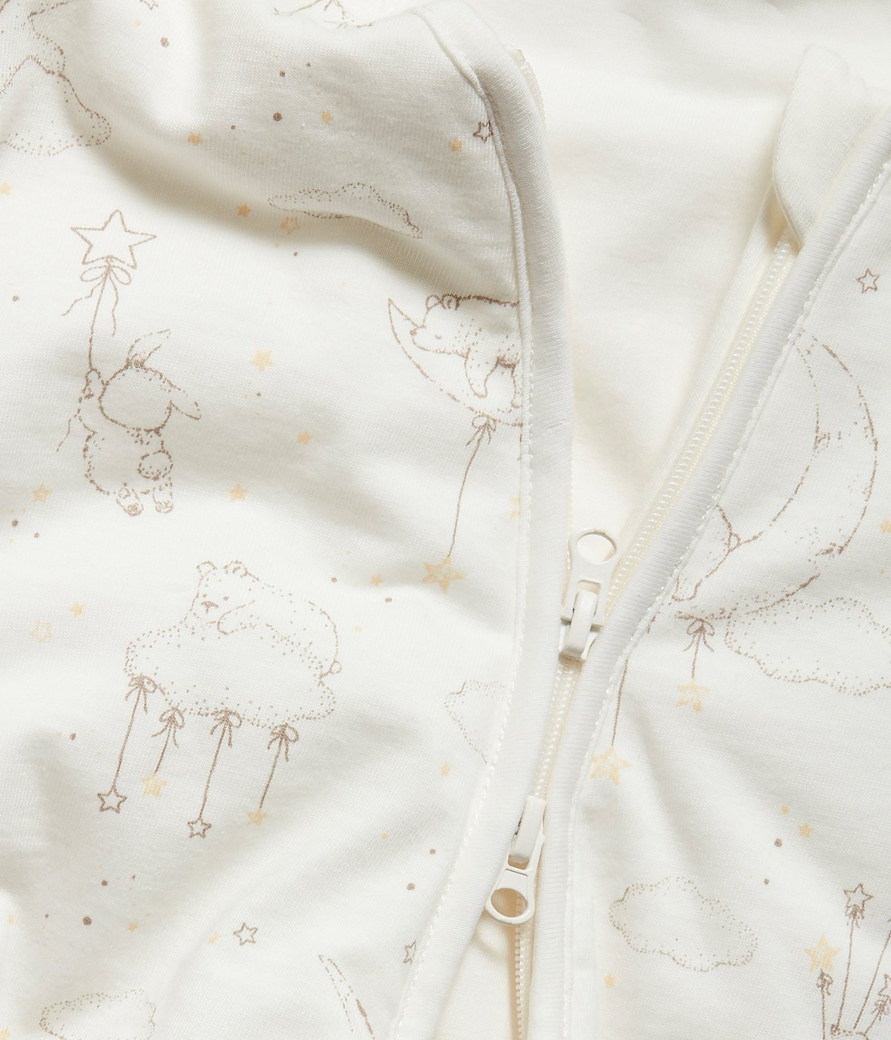 Close-up: Off-white baby sleeping bag with bears, rabbits, clouds pattern, and a two-way zipper.