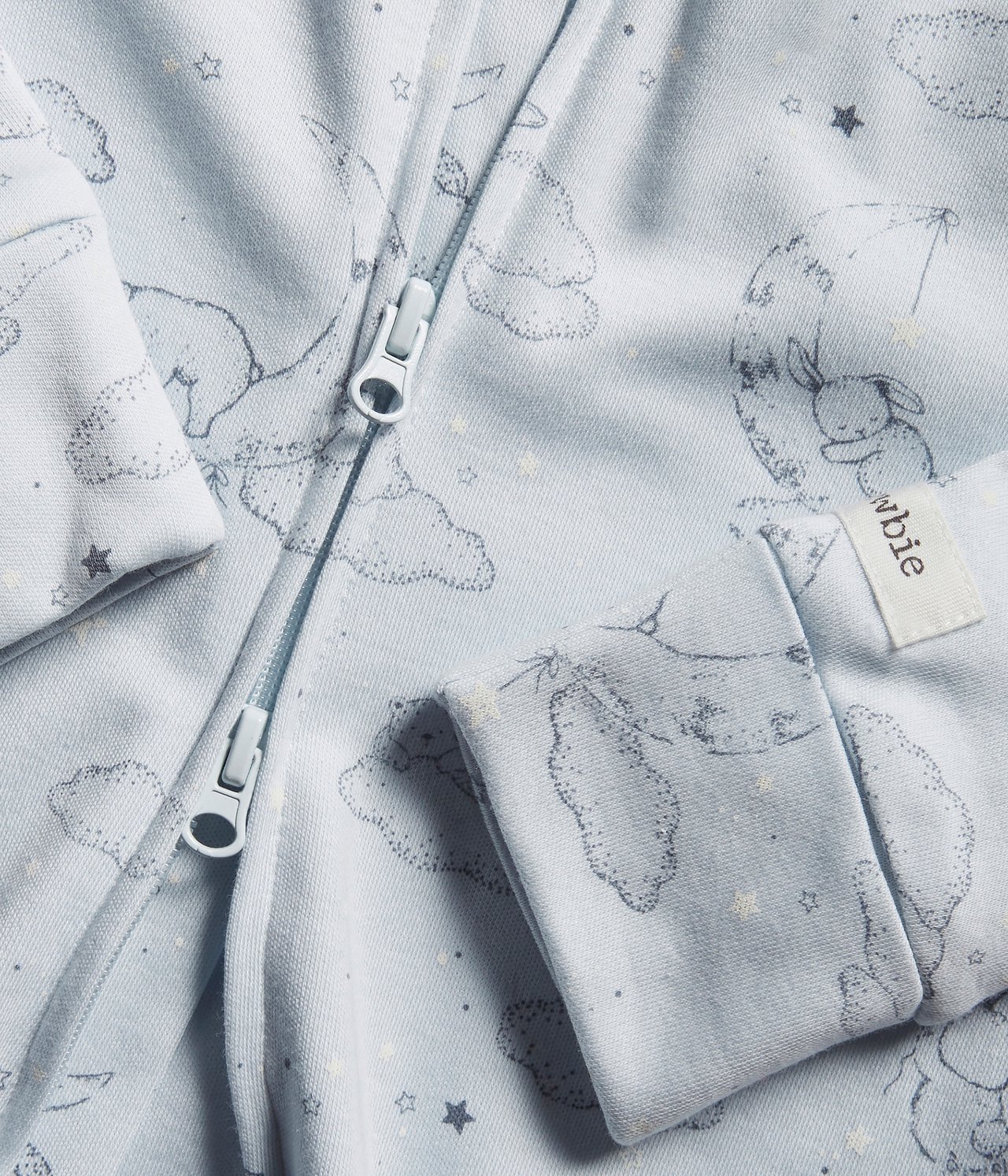 Close-up of a light blue cotton baby pajama with bear, star, moon pattern, two-way zipper, and cuffs.