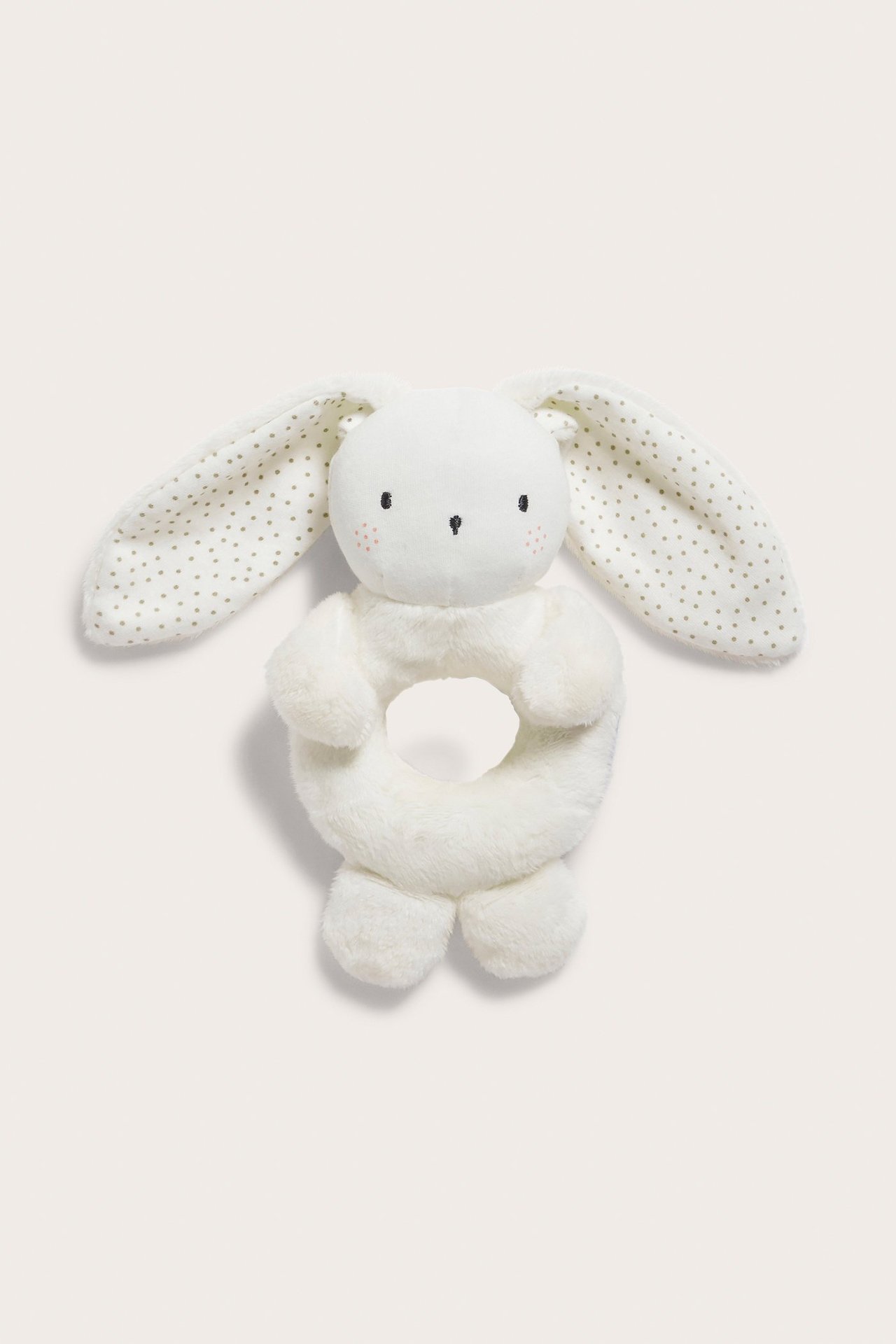 Front view of an off-white plush rabbit baby rattle with polka dot ears and embroidered face.