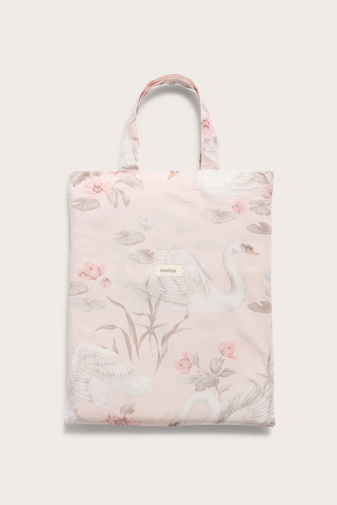 Vorderansicht: Hellrosa Baumwoll-Bettwäscheset mit Schwan- und Blumenmuster, gefaltet in passender Tragetasche.