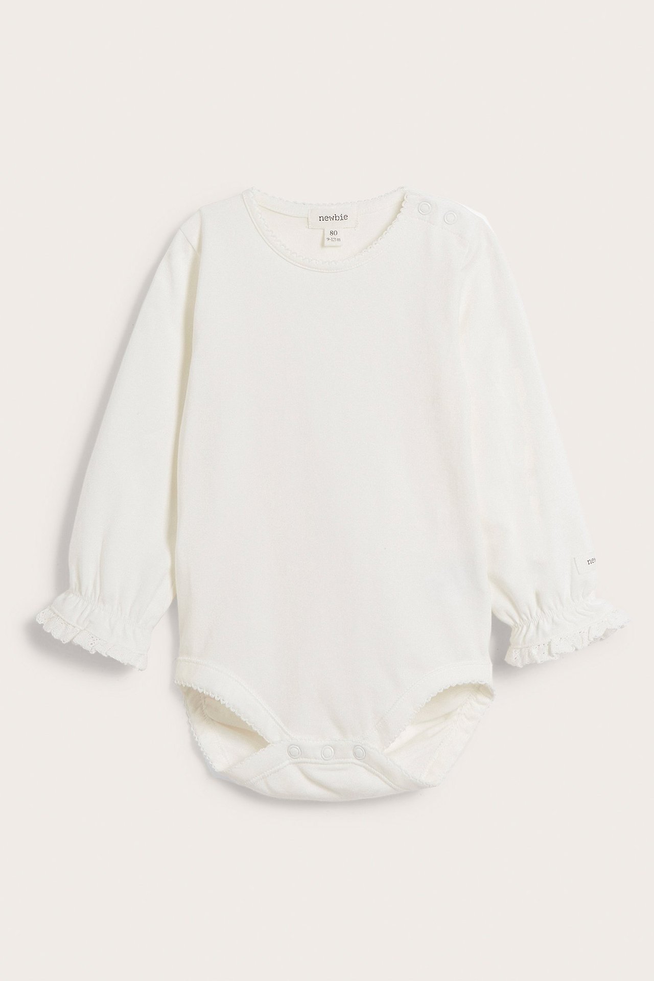 Front view of an offwhite long-sleeved baby bodysuit with picot trim neckline, snap buttons, and ruffled lace cuffs.